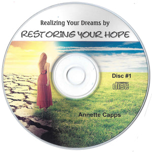 CD disc with a woman in a red dress standing on a beach, text 'Realizing Your Dreams by Restoring Your Hope' by Annette Capps. cappsministries.com