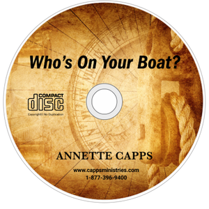 Compact disc with 'Who's On Your Boat?' text and Annette Capps' name on a wooden texture background cappsministries.com