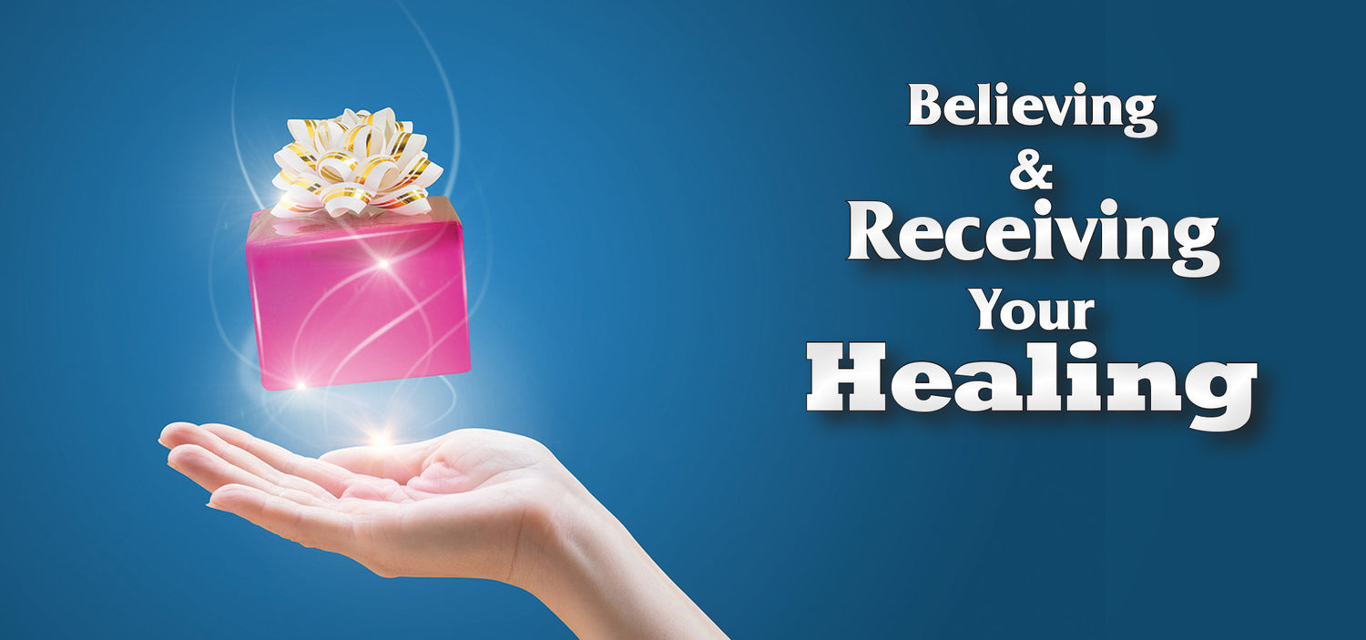 Hand holding a glowing pink gift box with text 'Believing & Receiving Your Healing' on a blue background Charles Capps cappsministries.com