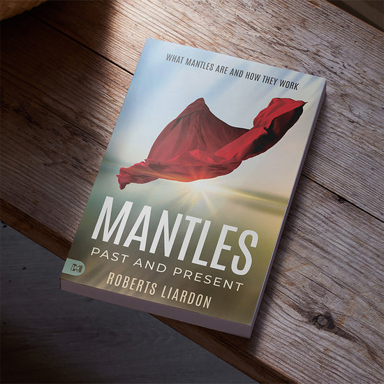 Book titled 'Mantles: Past and Present' by Roberts Liardon on a wooden surface