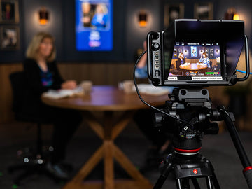 Video camera on a tripod recording a scene with a blurred background, CappsMinistries.om