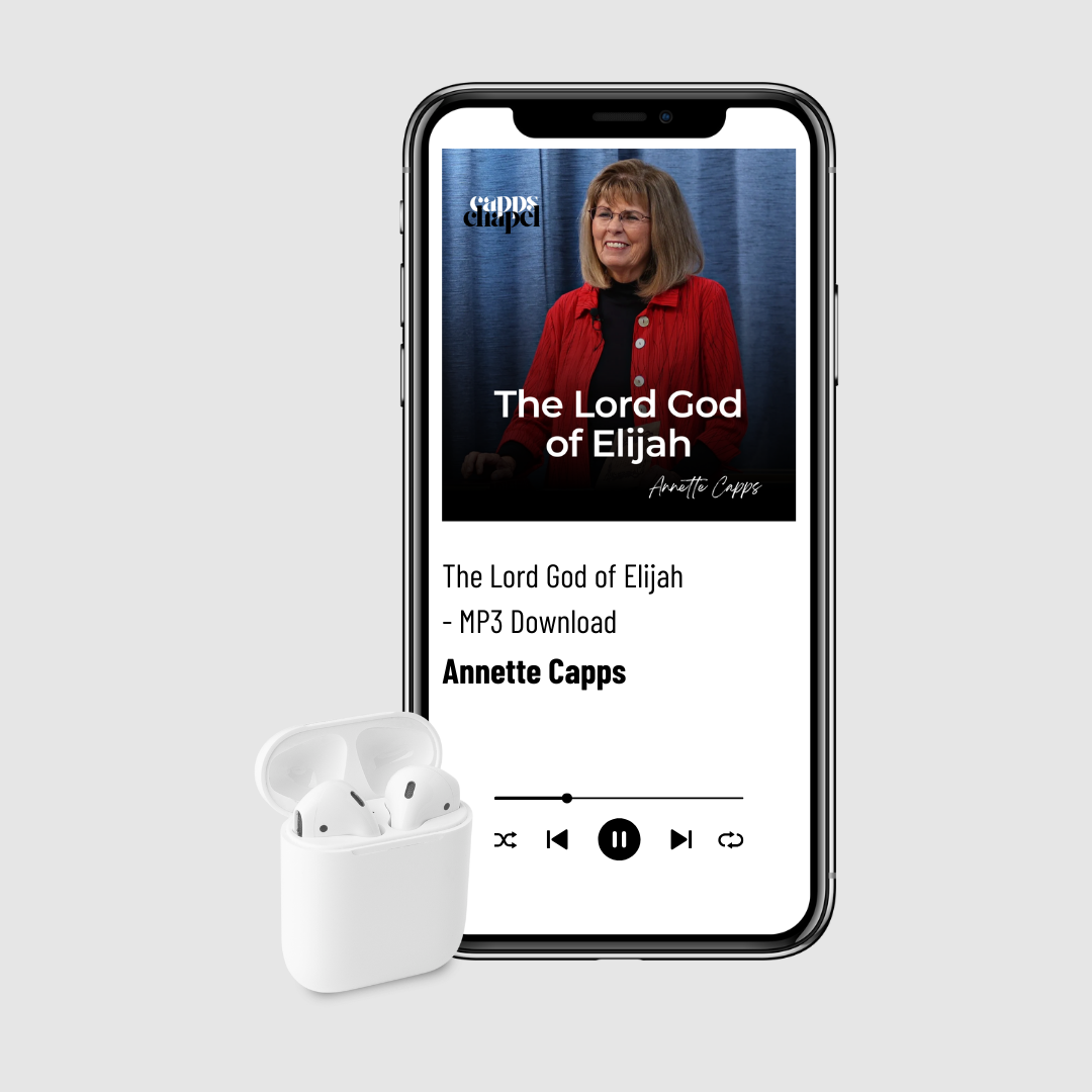 Smartphone displaying a music app with a song by Annette Capps and a white wireless earbud case on a light gray background.